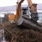 Roger Slee operates a digger to clear up a section in Kurow's main street, part of community...