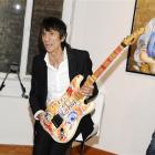 Rolling Stones guitarist Ronnie Wood holds up one of his works of art during a news conference...