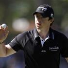 Rory McIlroy of Northern Ireland holds up his ball after a birdie on the third hole during the...