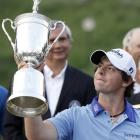 Rory McIlroy, of Northern Ireland, looks at the trophy after winning the US Open in Bethesda,...