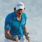 Rory McIlroy of Northern Ireland reacts after becoming golf's new world number one with his win...