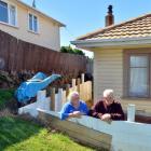 Rose McRobie and her father  examine the retaining wall  they had to build  in their backyard...