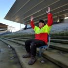 Rotarian Brendan Bearman tries out one of the last seats left in the Railway Stand at Carisbrook...