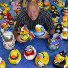 Rotary Club of Dunedin East member Barry Johnston lies among decorated rubber ducks. Photo by...