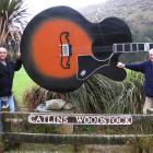 Russell Kirk (right) hands over the Catlins Woodstock Festival to Kev Thompson. Photo supplied.