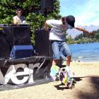 Sam Maxwell, of Queenstown, performs tricks on his skateboard, while DJ Matt Smith entertains the...
