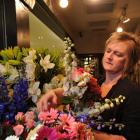 Sandra Lang selects blooms at Marguerita Florist in the Meridian Mall. Photo by Craig Baxter.