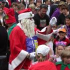 Santa Claus attracts a big crowd for a lolly scramble after he arrives at the Waimate Strawberry...