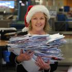 Santa's letter helper Colleen Eckhoff, of New Zealand Post, sorts through piles of Dear Santa...