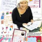 Santa's little helper Colleen Eckhoff, of New Zealand Post, reads someof the thousands of letters...