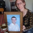 Sarah McCabe holds a photograph of her late son, Tony Wood, alongside the cup he recently won at...