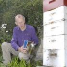 School teacher, reviewer and now author Raymond Huber smokes his backyard beehive. Photo by...