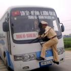 Second Lt. Nguyen Manh Phan clings on to the windshield wipers of a moving bus after the driver...