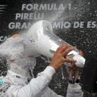 Second-placed Nico Rosberg (L) sprays champagne at winner Lewis Hamilton after the Spanish Grand...