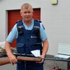 Senior Constable Murray Hewitson, of Owaka, with the BSA air rifle found with  property recovered...
