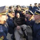 Servicemen throw a pilot in the air as they gather to welcome Russian military aircraft and...