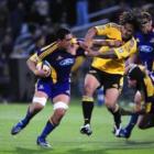 Highlander's star no 8 Steven Setephano is collared by Hurricanes winger Ma'a Nonu.  Photo by Craig Baxter