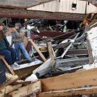 Sherry Cousins and her brother Bruce Wallace sit in the wreckage of their secondhand store in...