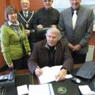 Signing a trust deed this week are Hearts and Hands for Haiti trustees Bruce Albiston (seated,...