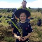 Sinclair Wetlands co-ordinator Glen Riley helps Sacred Heart School pupil Orla Kelly (10) as she...