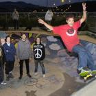 Skateboarder Chey Grace (21) shows his skill at the Dunedin Skateboard Park watched by (from left...