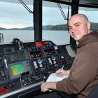 Skipper Turgut Ortabas completes a logbook in the catamaran's bridge while the vessel is moored...