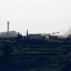 Smoke rises after shells exploded in the Syrian village of al-Jamlah, close to the ceasefire line...