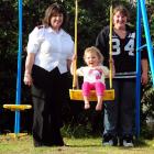 Solo mother Catherine Miller gives daughter Skyla a push on the swing while Salvation Army...