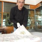 South Otago Museum curator Gary Ross with the supper cloth made by women in South Otago Plunket...
