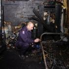 Southern region fire safety officer Stuart Ide examines the charred remains of a bedroom at a...