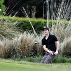 Southlander Liam Balneaves chips out from the rear greenside bunker on the third hole during the...