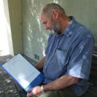 St Bathans Kiwibank customer Brian Jackson with his petition he is urging people to sign. Photo...