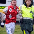 St John ambulance aider Karen Holland assists injured jockey Paul Hamblin after he fell during...