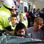 St John ambulance crew  and fire officer Geoff Finney (right) hold "patient" Jack Dobbie's head...