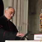 St Joseph's Cathedral priest Monsignor John Harrison accesses material on an iPad lying next to...