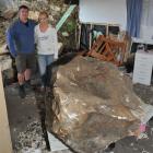 Steve and Jennie Roome are dwarfed by the large boulder which landed in their St Kilda, Dunedin,...
