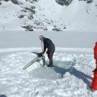 Steve Bell  cuts a hole in the ice on Lake Alta, watched by Dave Murdoch.