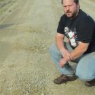 Steward Rd resident Robert Reed points out just some of the dozens of potholes that have appeared...