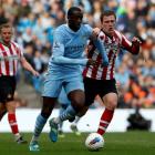 Sunderland's Craig Gardner (R) challenges Manchester City's Yaya Toure during their English...