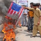 Supporters of Pakistan's Muslim League burn a representation of the US flag during a...