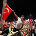 Supporters of Turkish Prime Minister Tayyip Erdogan shout slogans as they wait for his return at...