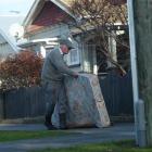 Surrey St resident Stuart Payne takes a damp mattress to a Dunedin City Council skip yesterday...