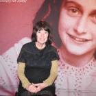 Susanne Ludanff, sits in front of an Anne Frank billboard at the Lakes District Museum on Sunday....