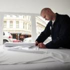 Dunedin man Jay Hutchinson cuts out a T-shirt in his makeshift ‘‘sweat shop’’ yesterday. Photo by...