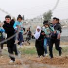 Syrians run as they flee from the Syrian town of Ras al-Ain to Turkish border town of Ceylanpinar...