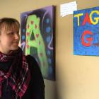 TAG co-ordinator Esther Dupu admires some of the graffiti art canvases on display at Ground Zero....