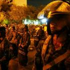 Thai soldiers stand guard with shields as they block a street to avoid a clash between Thai pro...