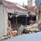 The brick and plaster rubble of a wall at 386 Princes St, Dunedin, lies on a neighbouring roof...