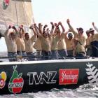 The crew members of New Zealand's Black Magic celebrate as they cross the finish line in the...