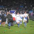 The French team are pelted with bottles as they celebrate their win at Carisbrook on Saturday...